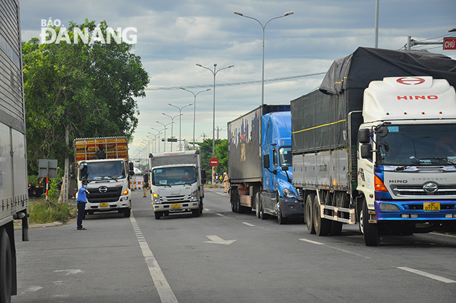 Lực lượng chức năng hướng dẫn xe vào chốt kiểm soát phòng, chống dịch trên quốc lộ 1A, gần Trạm Công an giao thông Hòa Phước, Hòa Vang để kiểm tra lái xe. Ảnh: THÀNH LÂN 