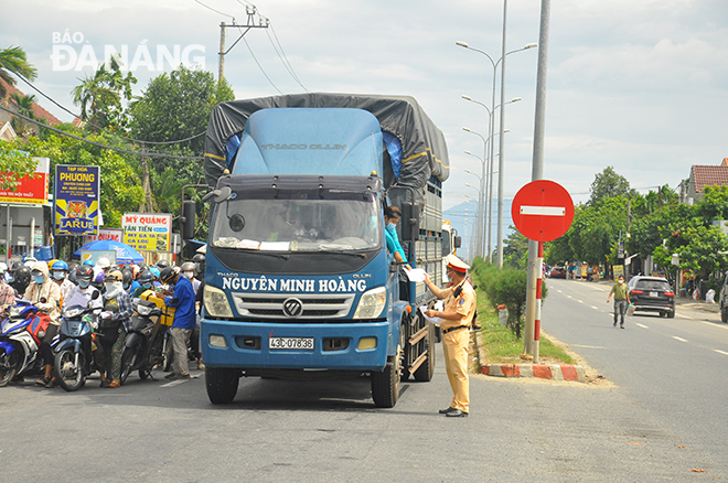 Lực lượng chức năng của tỉnh Quảng Nam kiểm soát nghiệm ngặt xét nghiệm y tế, giấy tờ xe, mã QR Code trước khi xe vào địa bàn Quảng Nam (ảnh chụp tại trạm kiểm soát giáp địa phận Đà Nẵng trên quốc lộ 1A. Ảnh: THÀNH LÂN 