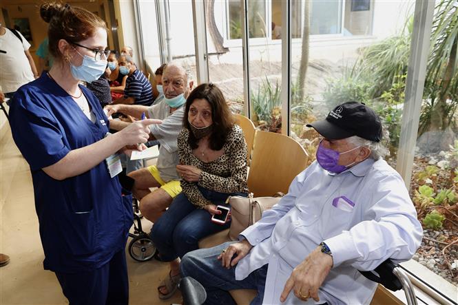 Người dân xếp hàng chờ tiêm vaccine Pfizer phòng COVID-19 tại Tel Aviv, Israel, ngày 12/7/2021. Ảnh: AFP/ TTXVN