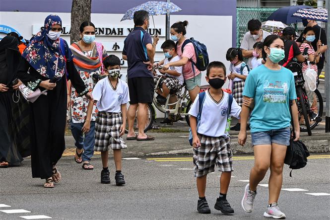 Người dân đeo khẩu trang phòng dịch COVID-19 tại Singapore. Ảnh: AFP/TTXVN