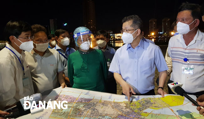 Secretary Quang (second, right) demanded the Son Tra District authorities to impose local lockdown order on some wards in the district following a rise in COVID-19 cases. Photo: PHAN CHUNG