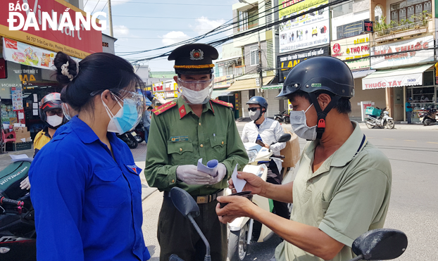 Lực lượng chức năng kiểm tra người dân ra vào tại chốt kiểm soát Covid-19 trên tuyến đường Trần Cao Vân (quận Thanh Khê). Ảnh: PHAN CHUNG	