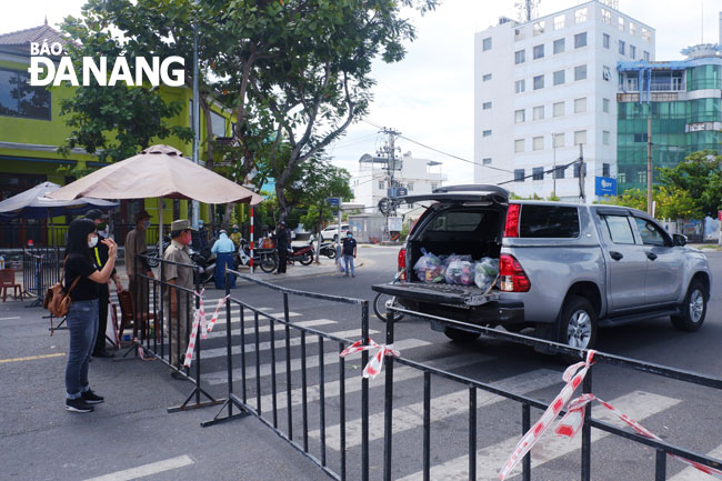 Đúng giờ hẹn, xe của đơn vị cung ứng thực phẩm có mặt tại chốt kiểm soát đường Trần Hưng Đạo - Nguyễn Thế Lộc (phường Nại Hiên Đông) để giao thực phẩm cho người dân trong khu phong tỏa. Ảnh: PHAN CHUNG