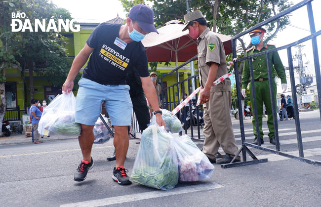 Representatives of community-based COVID-19 taskforces receive ordered food parcels for delivery to families in blockaded areas. Photo: PHAN CHUNG