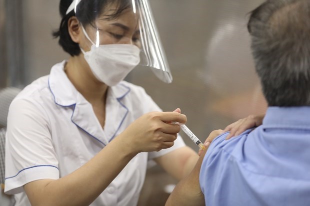 A medic injects a COVID-19 vaccine shot to a citizen (Photo: VNA)