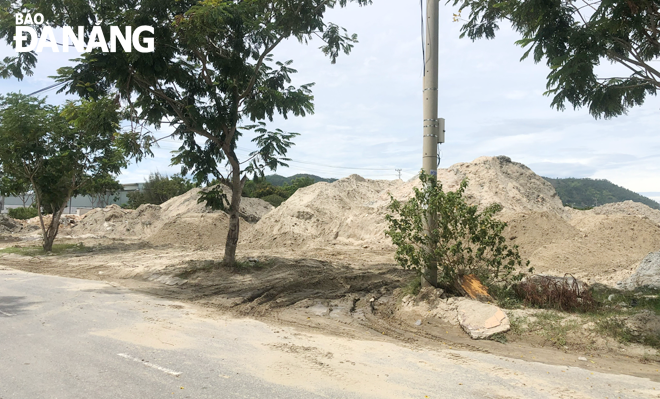 Bãi tập kết cát nằm tại góc đường Mê Linh - Lê Thương (phường Hòa Hiệp Nam, quận Liên Chiểu) không được che chắn gây ô nhiễm môi trường Ảnh: N.V	