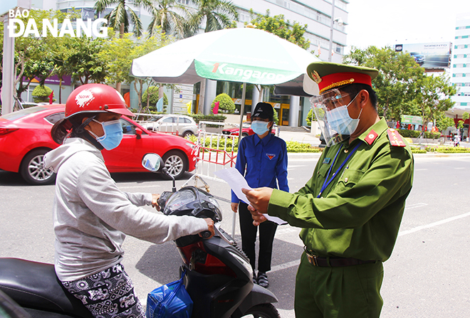 A police officer stops a motorbike rider to check his valid reason for leaving home