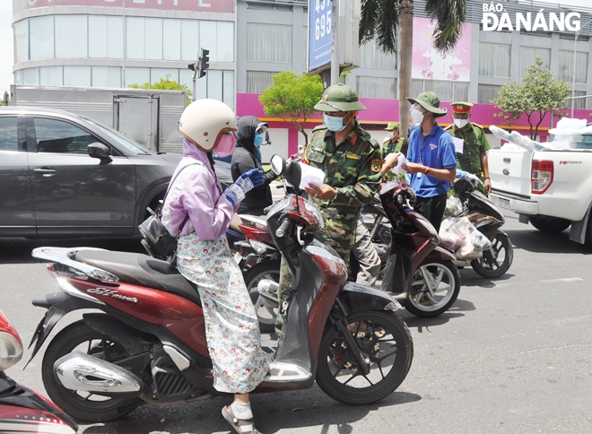 Lực lượng làm nhiệm vụ tại điểm chốt trên tuyến đường Điện Biên Phủ (quận Thanh Khê) kiểm tra giấy đi đường của người dân. Ảnh: LÊ HÙNG