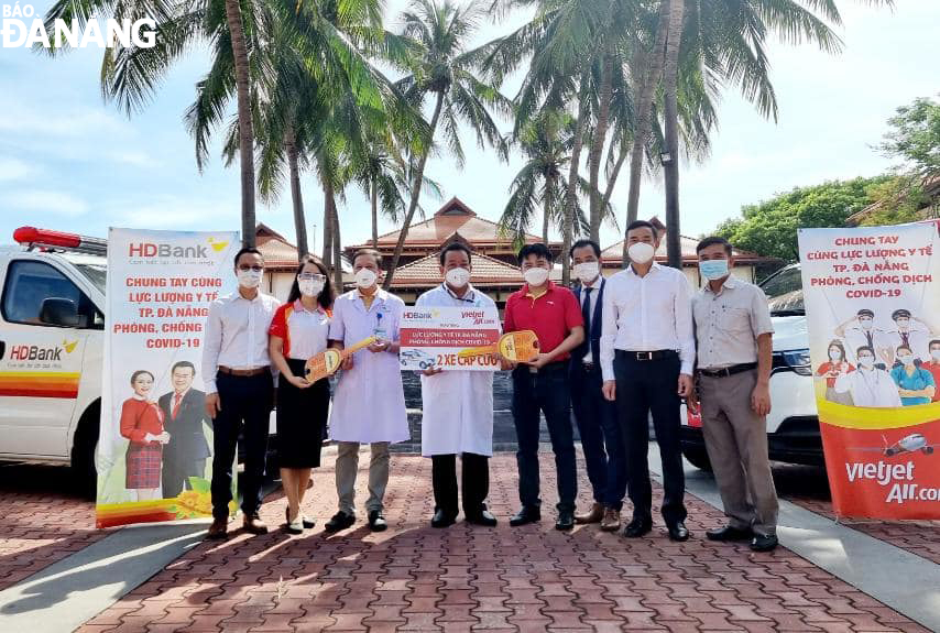 Da Nang Peoples Committee Chairman Le Trung Chinh (second, right), local health officials and ambulance donors pose for a photo.