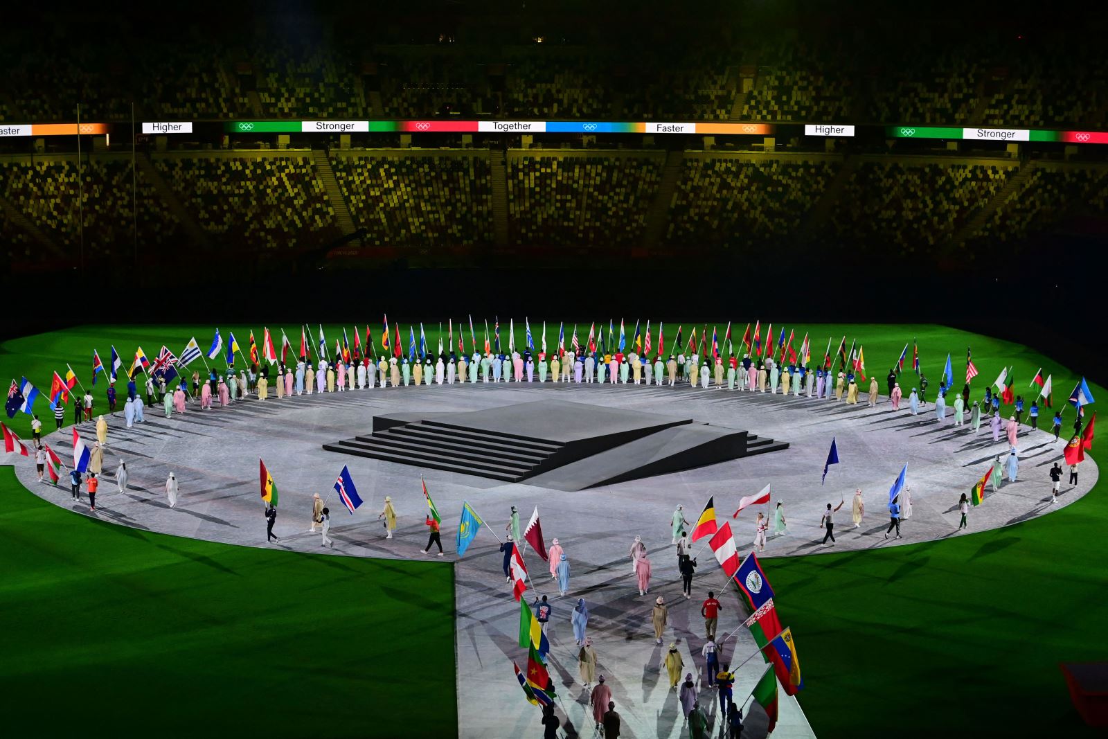 Đại diện các đoàn cầm quốc kỳ tiến vào trung tâm sân vận động Olympic. Ảnh: AFP