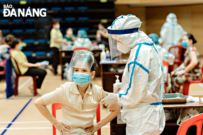 Da Nang is developing an action plan for COVID-19 vaccination rollout in order to make sure that all eligible people will attend the city’s vaccination campaign. In the photo: A woman got vaccinated against COVID-19 in the Tien Son Sports Palace in July 2021. Photo: PHAM DANG KHIEM