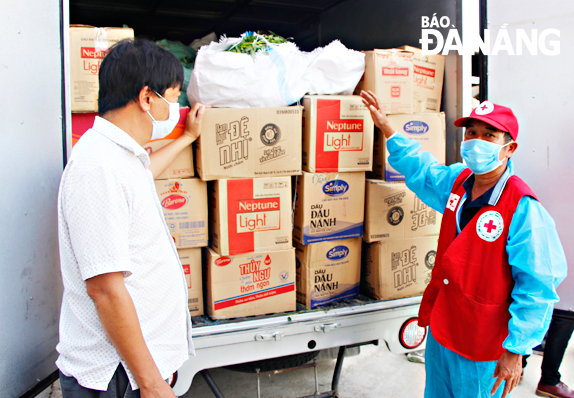 Các lực lượng phối hợp vận chuyển 30 tấn lương thực, thực phẩm của người dân huyện Đại Lộc (tỉnh Quảng Nam) gửi đến người dân trong khu cách ly của quận Sơn Trà.     Ảnh: XUÂN DŨNG