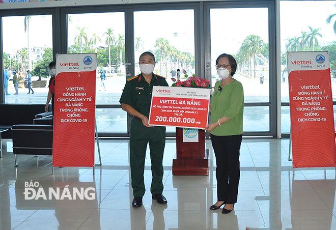 Senior Colonel Tran Dinh Quang, the Deputy Director of Da Nang branch of Viettel, handing a symbolic board of donations to a representative of the municipal Department of Health. Photo: THANH LAN