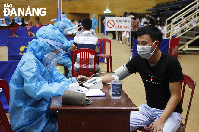 People who come to get vaccinated are required to undergo medical checks, and they are provided with medical advice and post-vaccination observation. Photo: XUAN DUNG.