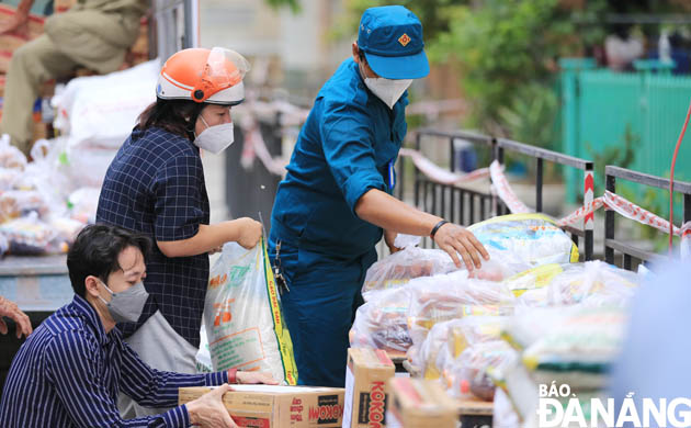 UBND phường Nại Hiên Đông (quận Sơn Trà) đưa lương thực, thực phẩm vào khu vực cách ly y tế để hỗ trợ người dân. Ảnh: ĐỨC HOÀNG 