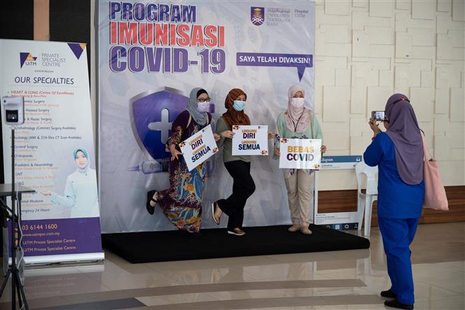 Nhân viên y tế tuyên truyền tiêm vaccine ngừa COVID-19 tại Sungai Buloh , Malaysia. Ảnh: AFP/TTXVN