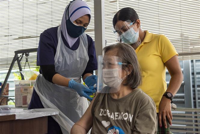 Nhân viên y tế tiêm vaccine phòng COVID-19 cho người dân tại Kuala Lumpur, Malaysia, ngày 29/7/2021. Ảnh: THX/ TTXVN
