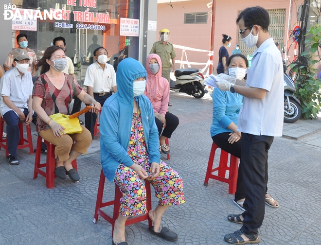 A public servant from the Hoa Thuan Dong Ward authorities in Hai Chau District specifically review list of locals for the sampling to avoid overlapping and omission, August 16, 2021 Photo: LE HUNG