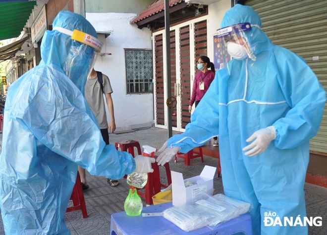 After completing the sampling on each person, medical staff carefully disinfect their hands to avoid catching the highly contagious virus, August 16, 2021 Photo: LE HUNG