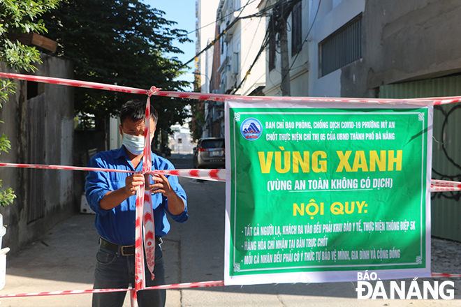 A youth union member of Ngu Hanh Son District’s My An ward, installing ropes to protect a COVID-free area known as a 