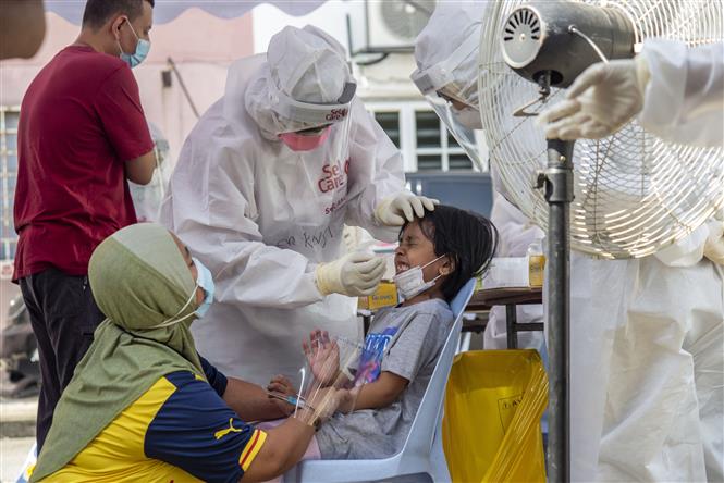 Nhân viên y tế lấy mẫu xét nghiệm COVID-19 cho trẻ em tại Subang, bang Selangor, Malaysia, ngày 14/8/2021. Ảnh: THX/TTXVN