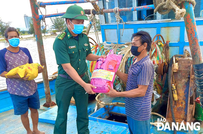 A border guard soldier give gifts to fishermen facing financial hardship due to COVID-19. Photo: HONG QUANG