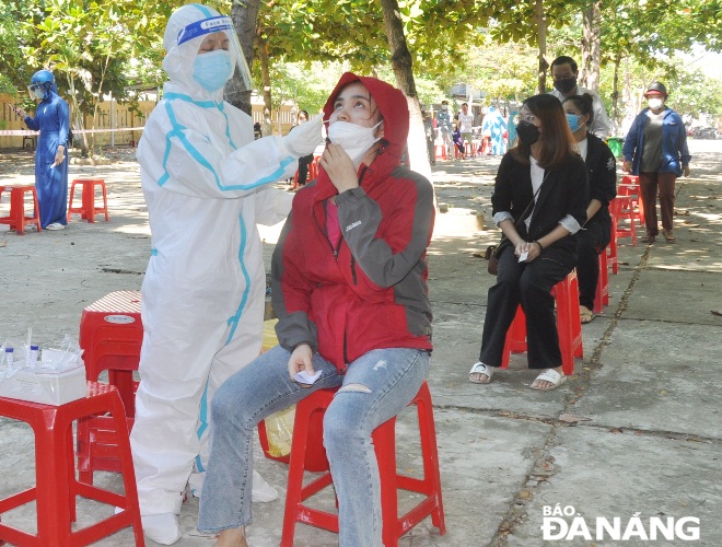 A medical worker in Son Tra District collects a nose swab for COVID-19 from a household representative in An Hai Dong Ward. Photo: LE HUNG