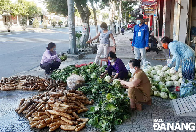 Members of the Hoa Khanh Bac Ward Womens Union clean vegetables and divide them into portions to distribute them to local people. Photo: TRONG HUNG