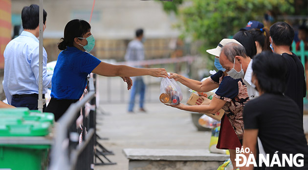 Chính quyền phường Nại Hiên Đông (quận Sơn Trà) hỗ trợ thực phẩm cho người dân trên địa bàn phường - nơi thực hiện cách ly y tế. Ảnh: ĐỨC HOÀNG