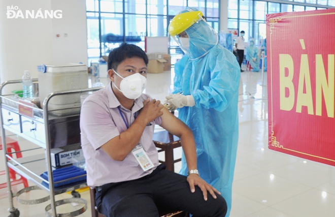 A healthcare professional in Cam Le District administering COVID-19 vaccine for an eligible man. Photo: LE HUNG