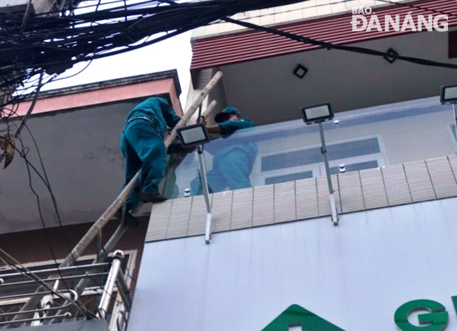 Tổ phản ứng nhanh của phường Thanh Bình (quận Hải Châu) bắc thăng leo lên tầng 2 của nhà dân để vào xử lý một sự cố. Ảnh: HOÀNG HIỆP