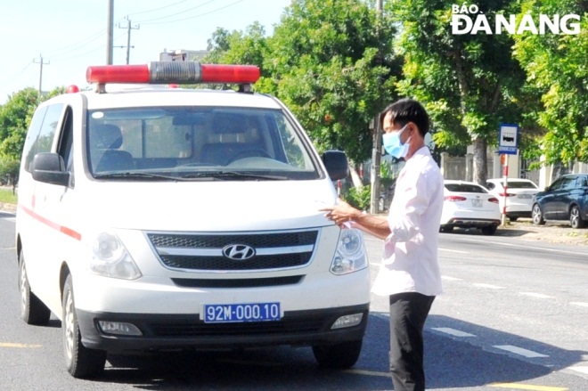  The driver of an ambulance has to make medical declaration and have his body temperature checked at the checkpoint.  Photo: LE HUNG