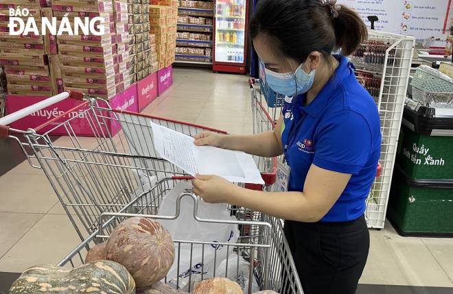 Nhân viên siêu thị Co.opmart Đà Nẵng soạn đơn hàng cho khách. Ảnh: QUỲNH TRANG