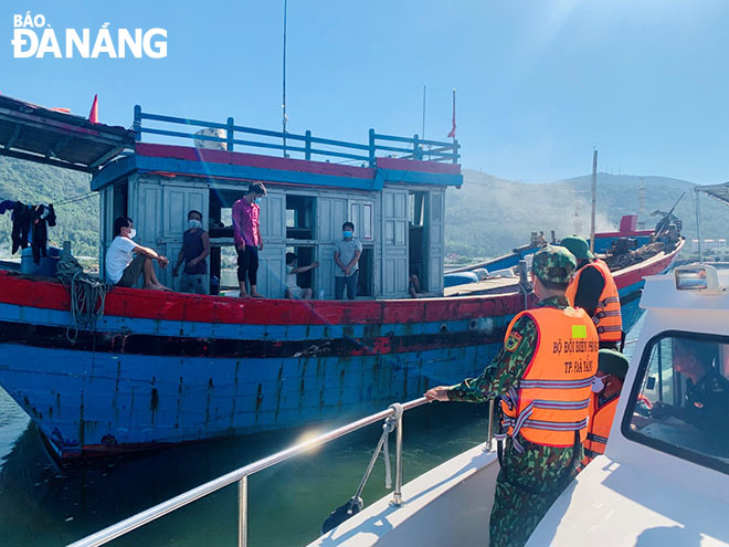 Bộ đội Biên phòng thành phố Đà Nẵng tuyên truyền, hướng dẫn ngư dân và thuyền viên chấp hành tốt quy định phòng, chống dịch. Ảnh: BÁ VĨNH