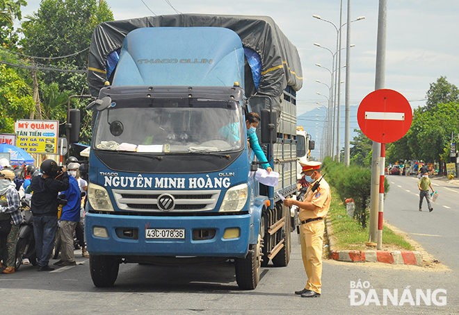 The competent force checks the driver's papers for the entry into the city. Photo: THANH LAN