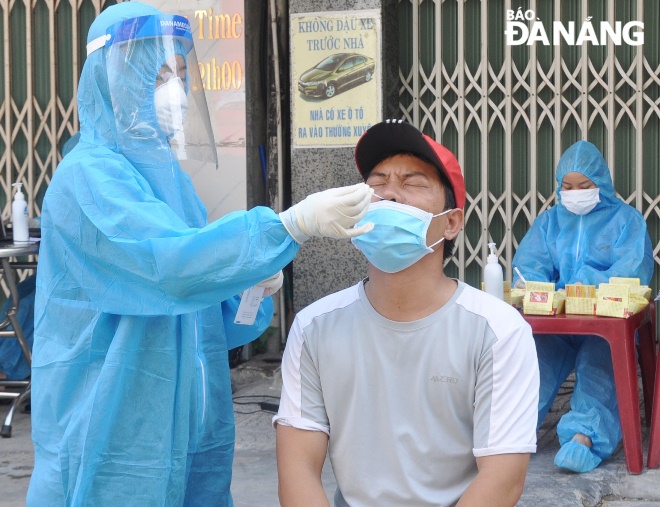 A healthcare worker in Hai Chau District took nasal swab of a household representative living on Hoang Dieu Street in the second round of the city’s screening program in the morning of August 20. Photo: LE HUNG