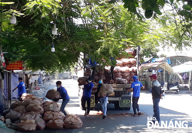 Youth union members are helping to unload vegetables from vehicles to timely distribute them to local residents. Photo: TRONG HUNG