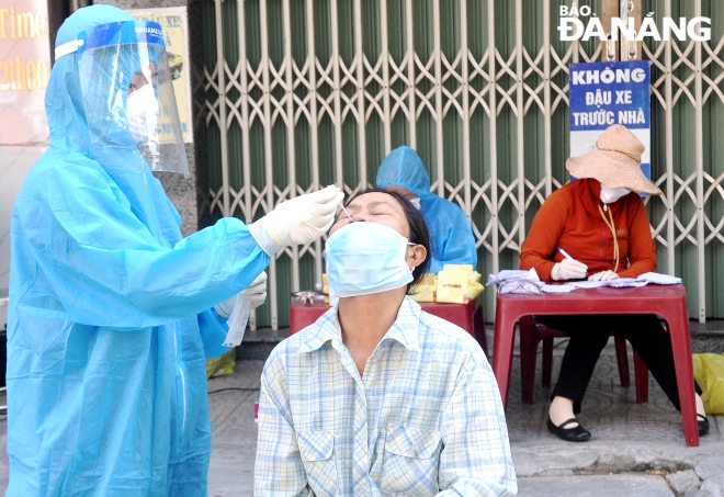 Functional agencies are accelerating the sampling rate of the ‘one door- one test’ campaign, putting more work pressure on medical staff in the laboratory. Photo: LE HUNG