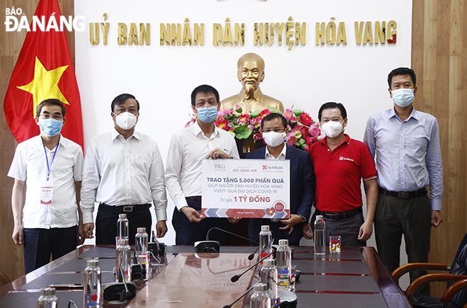 Representatives of the Hoa Vang District administration receive the symbolic board of the donations from the BRG Group and the (SeABank), August 22. Photo: XUAN DUNG