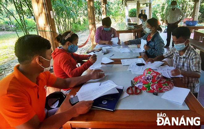 Tổ Covid cộng đồng thôn Tà Lang (xã Hòa Bắc) chuẩn bị phiếu xét nghiệm cho người dân. Ảnh: NGỌC ĐOAN