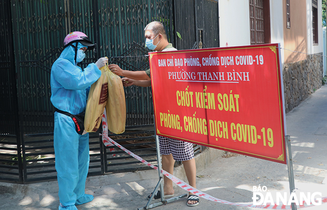 A shipper delivers goods to a residential checkpoint for delivery to families in Thanh Binh Ward, Hai Chau District. Photo: VAN HOANG