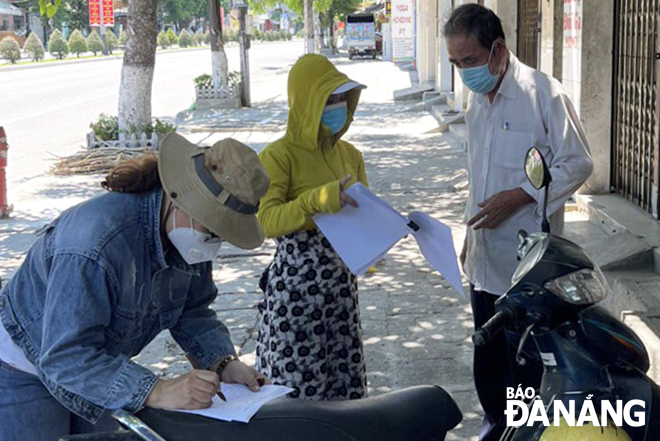 Officials of Hoa Khanh Nam Ward, Lien Chieu District present money to support locals here. Photo: PHUONG CHI