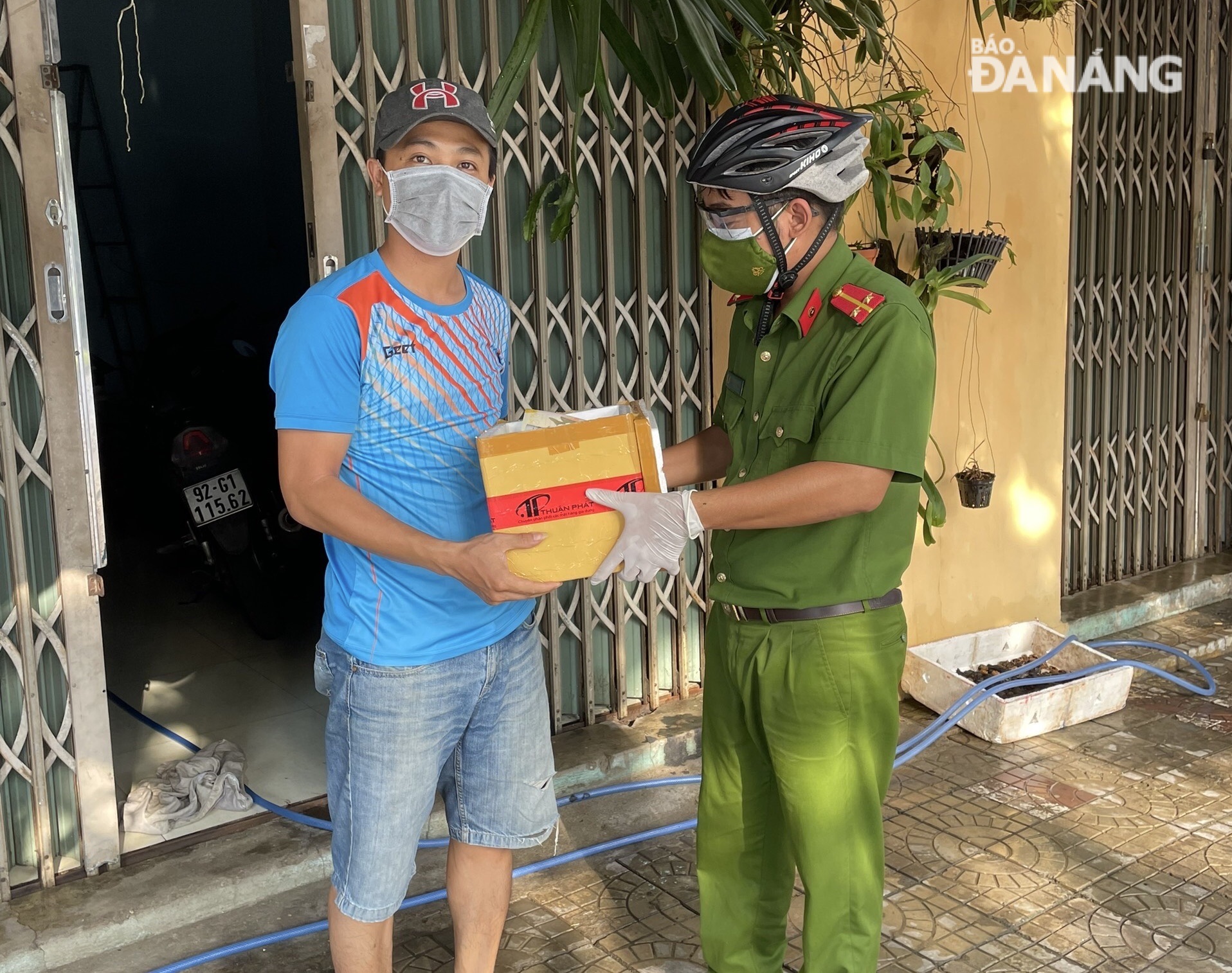 Lieutenant Nguyen Xuan Thien delivers frozen breast milk to the 3-day-old baby of  Mr Pham Phu Thinh living  in residential group No.5, Dong Hoa Village. Photo courtesy of the Hoa Chau Commune Police