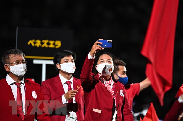 Đoàn thể thao Việt Nam diễu hành tại Lễ khai mạc Paralympic Tokyo 2020. (Ảnh: AFP/TTXVN)