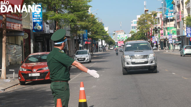 Military forces at the checkpoint on a section of Le Duan Street pull over vehicles for the check over legitimate papers