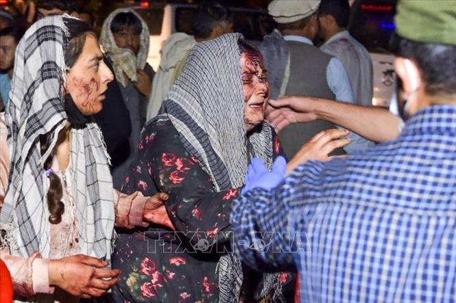 Nhân viên y tế hỗ trợ người bị thương trong vụ nổ bên ngoài sân bay quốc tế ở Kabul, Afghanistan. Ảnh: AFP/TTXVN