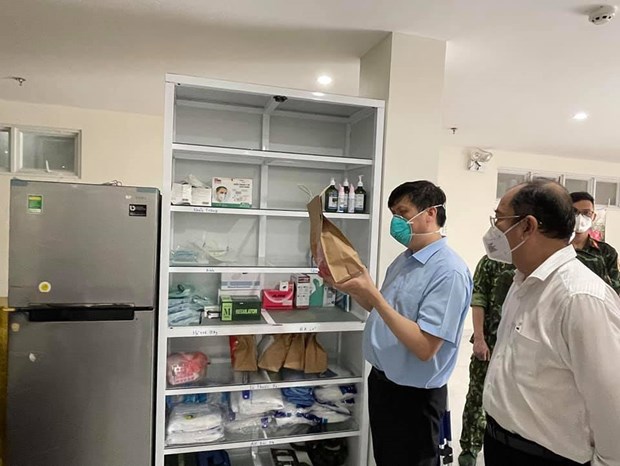 Bộ trưởng Bộ Y tế kiểm tra túi thuốc điều trị ngoại trú cho người nhiễm Covid-19 tại nhà. (Ảnh: PV/Vietnam+)