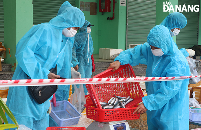  At the Cam Le District-based Hoa An Market, stall holders are required to wear protective clothing when selling goods to shoppers. Photo: VAN HOANG