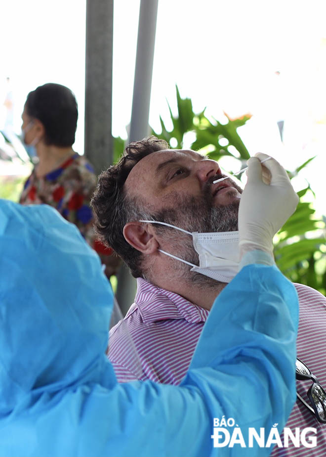 A healthcare worker taking nasal swab of a household representative to test for COVID-19