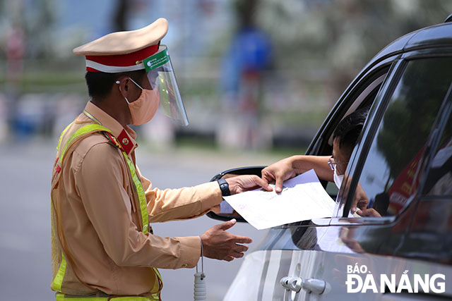 Lực lượng Công an thành phố Đà Nẵng kiểm soát giấy đi đường của người tham gia giao thông trong thời gian giãn cách xã hội để phòng, chống Covid-19. Ảnh: ĐỨC HOÀNG